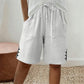 🩳✨ Shorts feminino de verão com cintura ajustável e detalhe elegante de botões laterais
